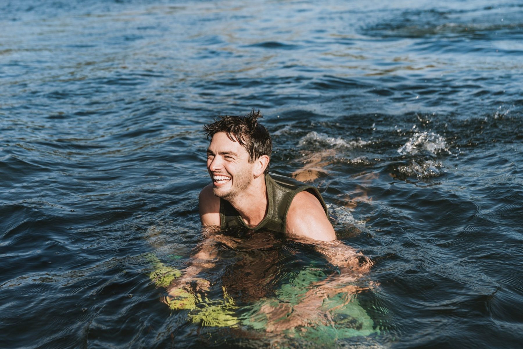 Anthony Arts laughing while swimming in a lake